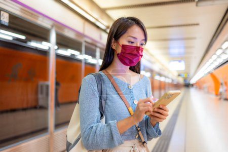 Frau trägt Gesichtsmaske in U-Bahn-Station in Hongkong
