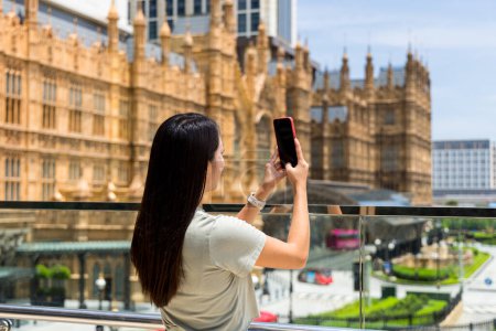 Foto de Mujer turista utiliza el teléfono inteligente para tomar una foto en la ciudad de Macao - Imagen libre de derechos