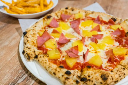 Téléchargez les photos : Pizza hawaïenne tropicale avec tranches d'ananas et jambon - en image libre de droit