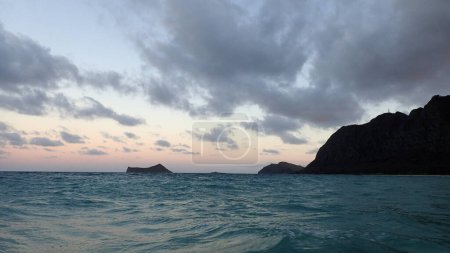 Photo for Gentle wave out in Waimanalo Bay looking towards Rabbit island and Rock island at dusk in Oahu, Hawaii. Taken on November 21, 2021. - Royalty Free Image