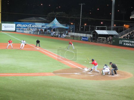 Photo for Honolulu - March 8, 2013:  Swing and a hit! The ball collides with the ground after Gonzaga University batter makes contact at the baseball game. - Royalty Free Image