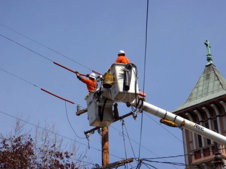 Foto de San Francisco - 31 de marzo de 2009: Hombres de una grúa en un poste de servicio público trabajando en una línea eléctrica. - Imagen libre de derechos