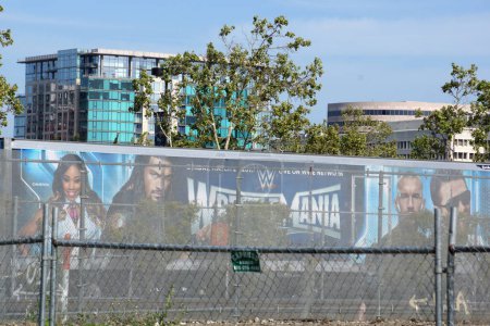 Téléchargez les photos : San Jose - 30 mars 2015 : Affiche WWE Truck with Wrestlmania mettant en vedette Roman Reigns, Randy Orton et le Miz derrière une clôture. - en image libre de droit