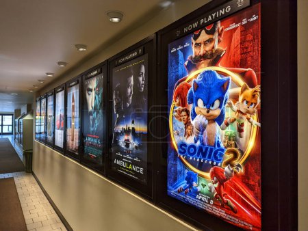Foto de Honolulu - 11 de abril de 2022: Fila de carteles de películas que incluyen Sonic the Hedgehog 2, Ambulance, Morbius y otros fuera del cine en Kahala Mall. - Imagen libre de derechos