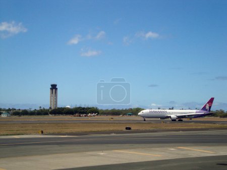 Foto de Honolulu - 9 de abril de 2010: Aviones de Hawaiian Airlines estacionados en el Aeropuerto Internacional de Honolulu en un día soleado. El avión presenta el diseño floral de la firma de las aerolíneas y el logotipo en la cola. - Imagen libre de derechos