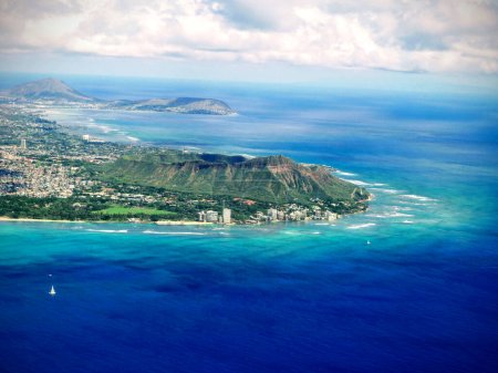 Foto de Embárcate en un viaje visual mientras te elevas por encima de Oahu, Hawaii, capturando una impresionante vista aérea de sus magníficos paisajes. Esta cautivadora toma muestra el icónico Diamondhead, la exuberante vegetación del Parque Kapiolani, la vibrante energía de W - Imagen libre de derechos