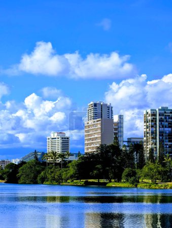 The Ala Wai Canal in Honolulu presents a harmonious blend of nature and urban development, with its calm waters mirroring the clear blue skies and the citys modern architecture. 
