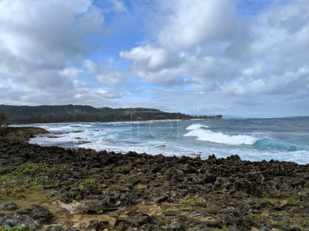 A serene view of the powerful yet peaceful waves crashing against the rocky shores of Turtle Bay, located on the iconic North Shore of Oahu.