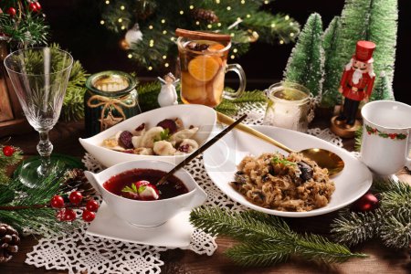 Foto de Sopa de borscht rojo de Nochebuena con raviolis rellenos de champiñones y patatas fritas de remolacha y chucrut con champiñones en la mesa festiva - Imagen libre de derechos