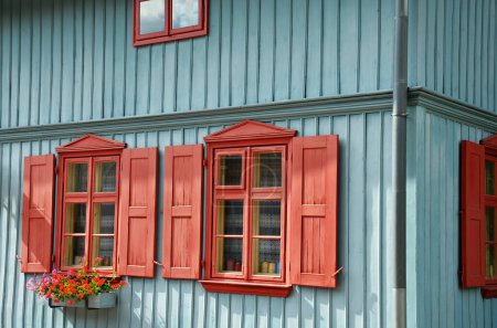 Photo for Closeup of restored old blue wooden house with red shutters - Royalty Free Image