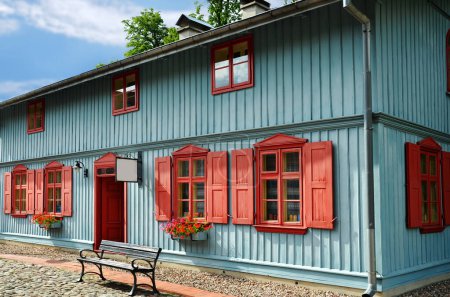 Photo for Beautiful restored old blue wooden house with red shutters and door - Royalty Free Image