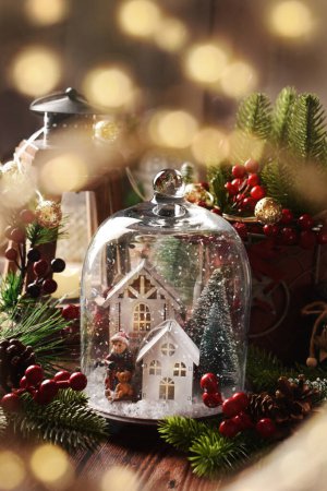 Téléchargez les photos : Décoration de table de Noël avec petites maisons et scène d'hiver à l'intérieur de cloche en verre - en image libre de droit
