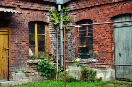 Old brick building of lumber rooms or sheds in the yard of workers' housing estate