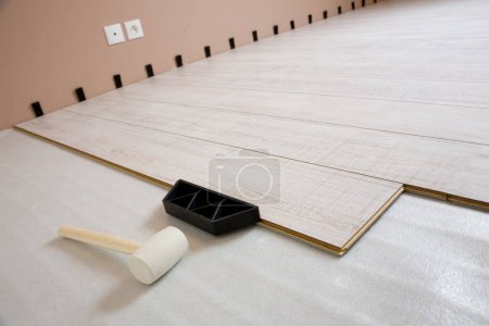 Téléchargez les photos : Installation de nouveaux planchers de bois stratifié dans la maison et les outils - en image libre de droit