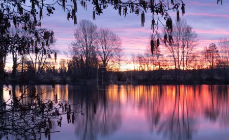 Foto de Foto de paisaje nocturno del río francés Adour después de la puesta de sol roja ardiente con nubes dramáticas flotando. Fotografía tomada en Francia - Imagen libre de derechos