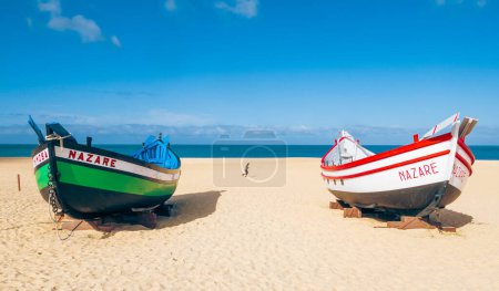 Téléchargez les photos : Nazare, Portugal - 20 mars 2024 : Vue de vieux bateaux de pêche sur la plage le 30 octobre 2023 à Nazare, Portugal - en image libre de droit