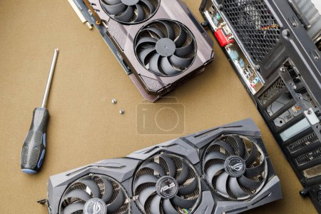 Photo for Graphics card upgrading concept, two gaming graphics cards near desktop miditower ATX pc case on tan fabric background in Tula, Russia - July 27, 2022 - Royalty Free Image