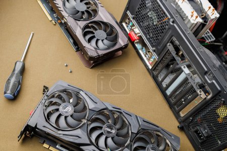 Photo for Graphics card upgrading concept, two gaming graphics cards near desktop miditower ATX pc case on tan fabric background in Tula, Russia - July 27, 2022 - Royalty Free Image