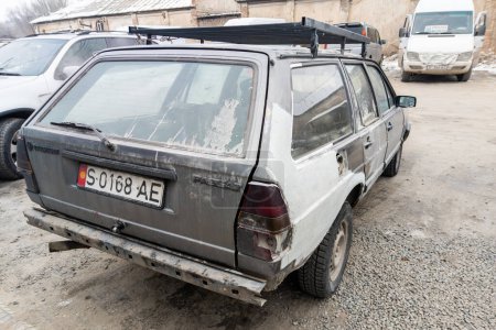 Téléchargez les photos : Vue arrière de la vieille Volkswagen Passat B2 Variante battue avec une épaisse couche de mastic et pare-chocs arrière manquant sur le parking à Sokuluk. Kirghizistan : 5 décembre 2022 - en image libre de droit