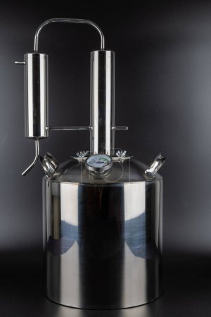 brand new stainless steel alcohol machine or moonshine still on black background.