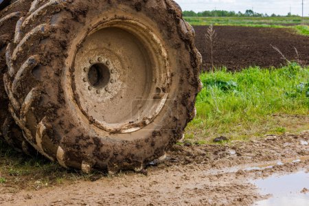 Foto de Sucia rueda doble de un tractor de agricultura grande en el camino de tierra en el día de verano, primer plano - Imagen libre de derechos