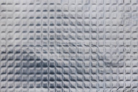 Texture plein cadre de feuille de caoutchouc butil enduit d'aluminium avec motif carré. Ce matériau est utilisé pour l'amortissement sonore dans les intérieurs de voiture et la réduction de la résonance vibratoire et l'amélioration acoustique.