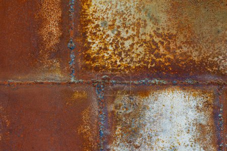 Photo for Close up of a brownish rusted welded sheet metal surface with yellowish and orange hue and amber patina. - Royalty Free Image