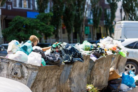 cubos de basura públicos sobrecargados en el día de verano en la gran ciudad, primer plano con enfoque selectivo