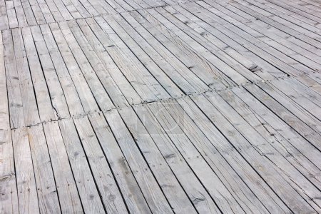 Primer plano de un suelo de cubierta de madera gris blanqueado por el sol.