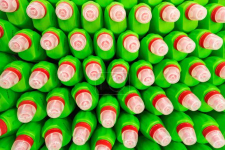 Green bottles of household toilet cleaning bleach gel with sodium hypochlorite, NaOCl with red and transparent caps. Full-frame closeup background with high angle view.