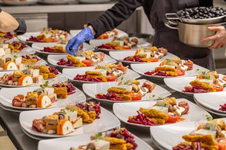 Téléchargez les photos : Un chef arrangeant une assiette d'amuse-gueule pour table de mariage - en image libre de droit