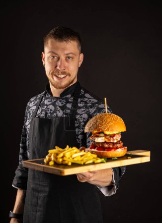 Foto de Comida callejera lista para servir. Hamburguesa grande con papas fritas - Imagen libre de derechos