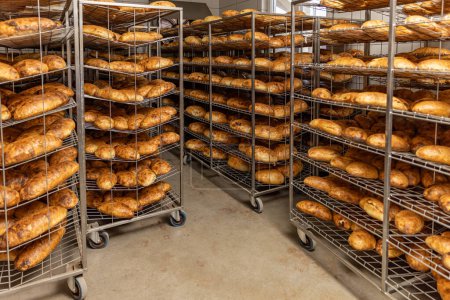 Photo for Freshly baked bread stacked and ready for packaging at factory - Royalty Free Image