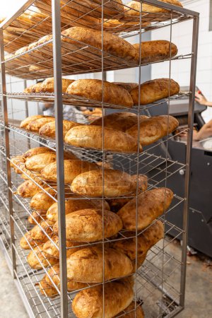Photo for Fresh bread inside of a bakery ready to sell. Industrial food production - Royalty Free Image
