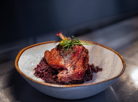 Roast duck leg served with red cabbage, restaurant menu concept