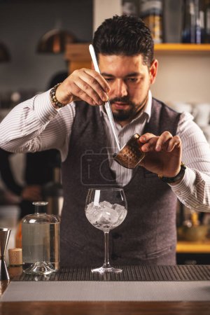 Skilled bartender meticulously measures a drink ingredient behind the bar