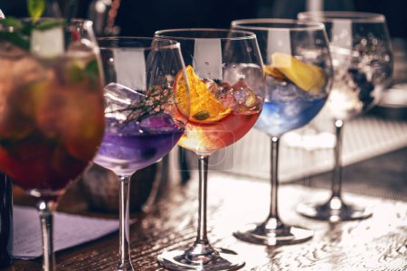 Téléchargez les photos : Assortiment de cocktails artisanaux colorés et vibrants servis dans des couverts sophistiqués sur un comptoir de bar - en image libre de droit