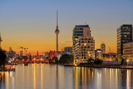 Rzeka Szprewa w Berlinie po zachodzie słońca ze słynną wieżą telewizyjną z tyłu