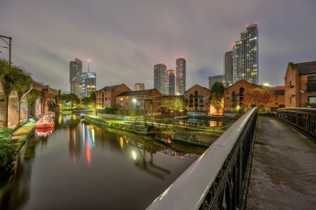 Foto de Castlefield en Manchester, Reino Unido, por la noche con el horizonte moderno en la parte posterior - Imagen libre de derechos