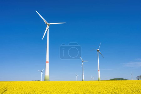 Wind turbines and a field of flowering rapeseed seen in Germany
