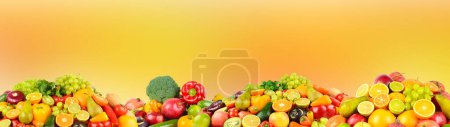 Foto de Gran colección de frutas, verduras y bayas sobre fondo naranja borrosa. - Imagen libre de derechos