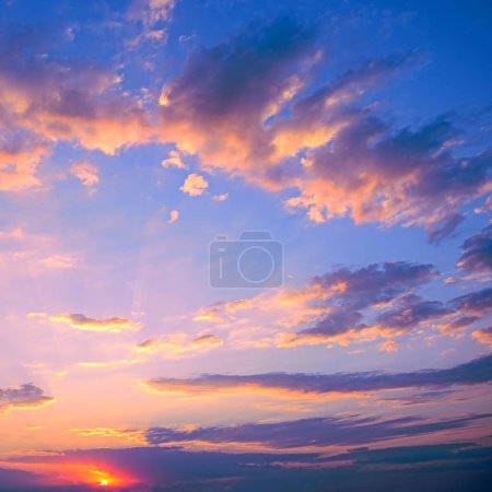 Téléchargez les photos : Fantastic pink sunset against blue sky with fluffy white clouds. - en image libre de droit