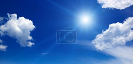 Téléchargez les photos : Bright sun on beautiful blue sky with white fluffy clouds. - en image libre de droit