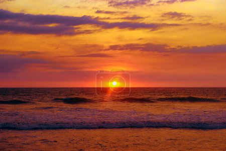 Téléchargez les photos : Coucher de soleil lumineux sur un océan calme. - en image libre de droit