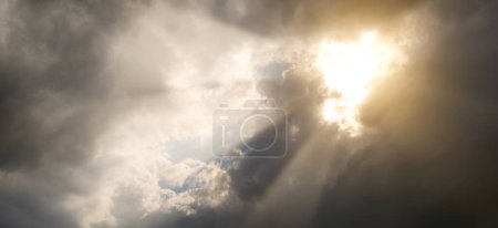 Téléchargez les photos : Rayons de soleil à travers des nuages de tempête noirs. - en image libre de droit