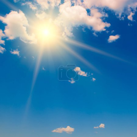 Photo for Blue sky with white fluffy clouds and bright sun with rays. - Royalty Free Image