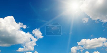 Téléchargez les photos : Bright sun on beautiful blue sky with white fluffy clouds. - en image libre de droit