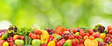 Foto de Collage fresh colored vegetables, fruits, berries on green background. Healthy food concept - Imagen libre de derechos