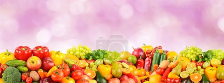Foto de Frutas y verduras brillantes multicolores sobre fondo lila borrosa. - Imagen libre de derechos