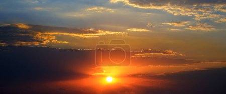 Foto de Fondo espectacular puesta de sol con sol brillante, cielo azul y pintorescas nubes. - Imagen libre de derechos